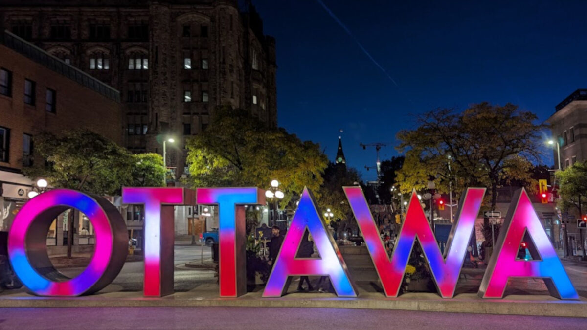 Colourful Ottawa sign, lit up at night.